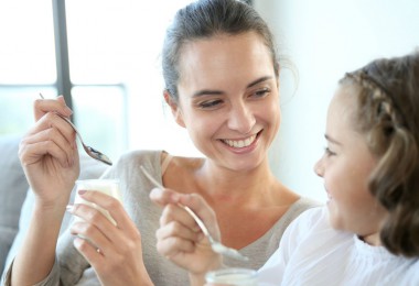 Mother and daughter eating yoghurt