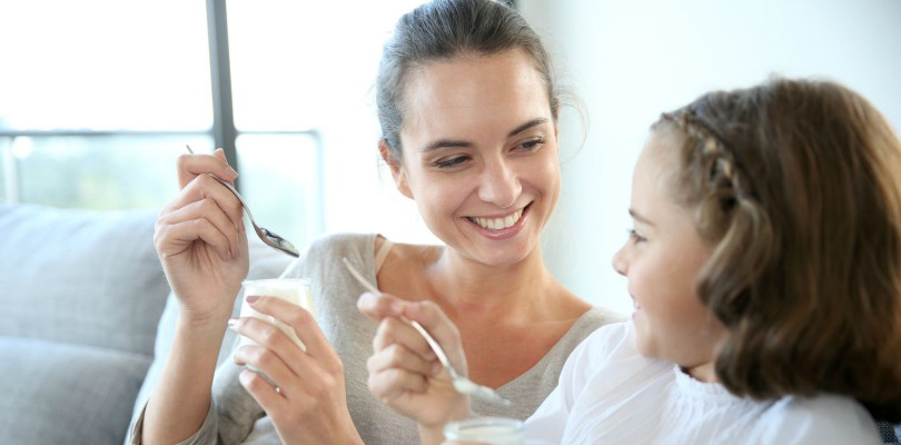 Mother and daughter eating yoghurt