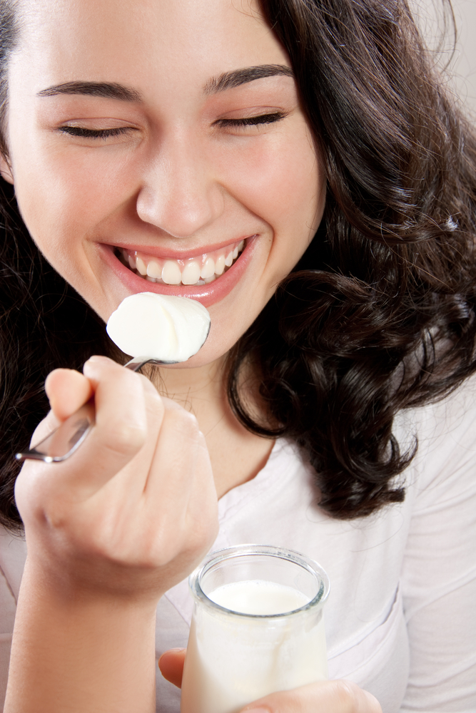young woman eating yogurt Yogurt in Nutrition