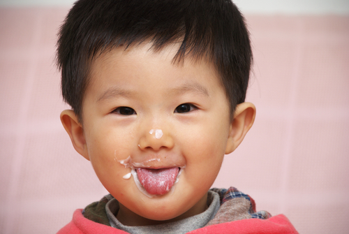 Asian child eating yogurt