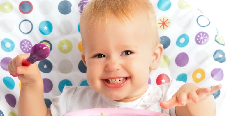 cheerful-happy-baby-child-eats-itself-with-a-spoon