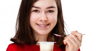 teenage girl eating yogurt
