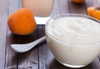 Yogurt with apricots in bowl on wooden background. Selective focus.