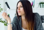 Portrait of beautiful young woman eating yogurt at home.