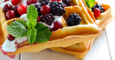 Breakfast with freshly baked belgian waffles with yogurt and berries