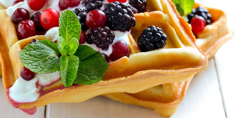 Breakfast with freshly baked belgian waffles with yogurt and berries